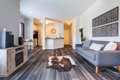 Large living room off of a kitchen with wood style flooring