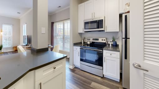 a kitchen with white cabinets and a stove and a microwave