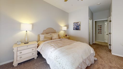 a bedroom with a bed and a dresser with two lamps