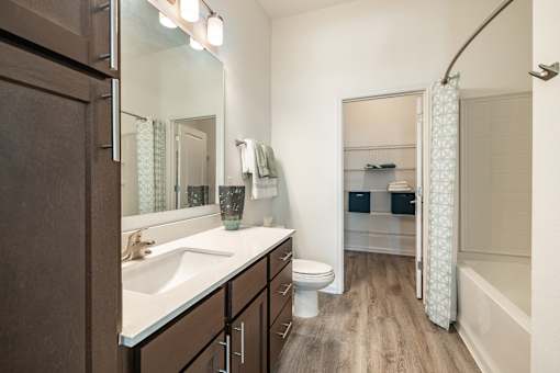 a bathroom with a large mirror and a sink and a toilet at Artesia at Lakewood Ranch Apartments, Bradenton, FL