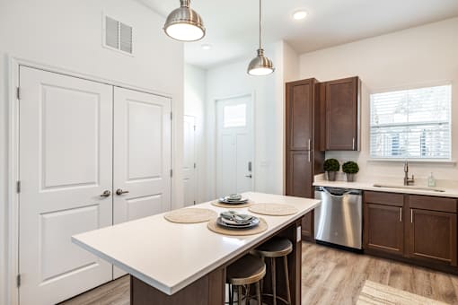 a kitchen with a white island and wooden cabinets at Artesia at Lakewood Ranch Apartments, Florida