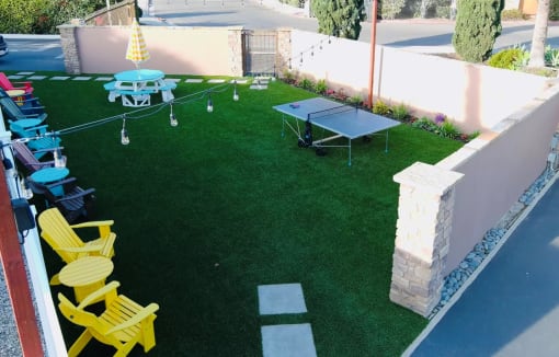 a backyard with synthetic grass and ping pong table