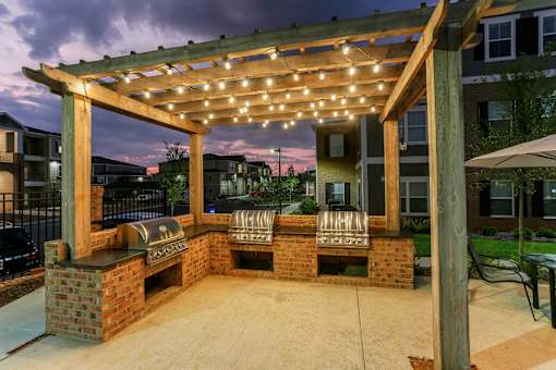 a brick patio with a pergola with lights on it at Annandale Apartment Homes, Tennessee