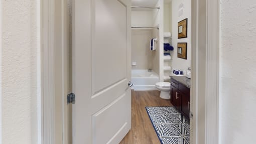 a bathroom with a white toilet next to a bathtub at Integra 360 Apartments, Florida
