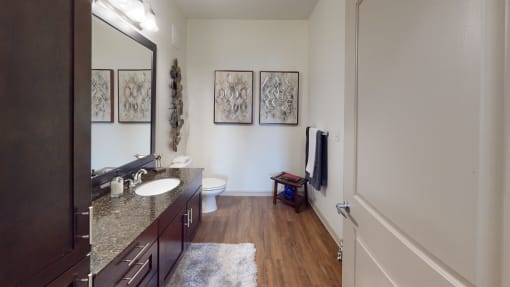 a bathroom with a sink mirror and toilet   at Integra 360 Apartments, Winter Springs, Florida