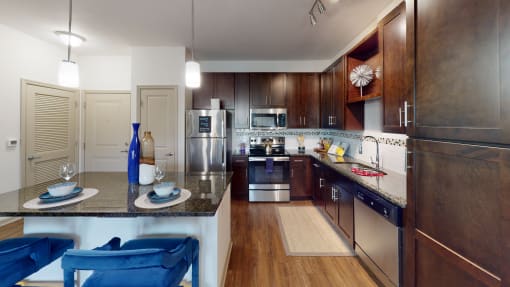 a kitchen with dark wood cabinets and stainless steel appliances at Integra 360 Apartments, Winter Springs