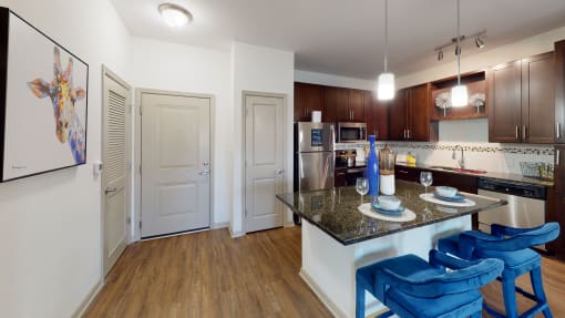 a kitchen with a granite counter top and stainless steel appliances at Integra 360 Apartments, Winter Springs, 32708