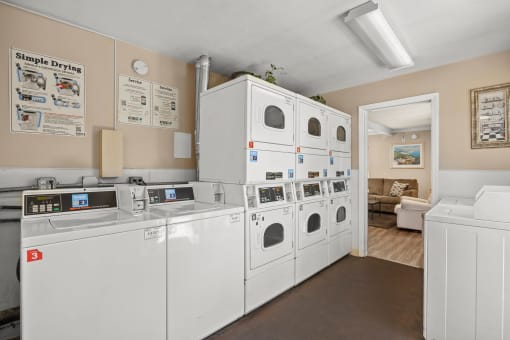 a laundry room with white washers and dryers