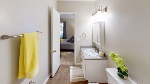 a bathroom with a white sink and a yellow towel