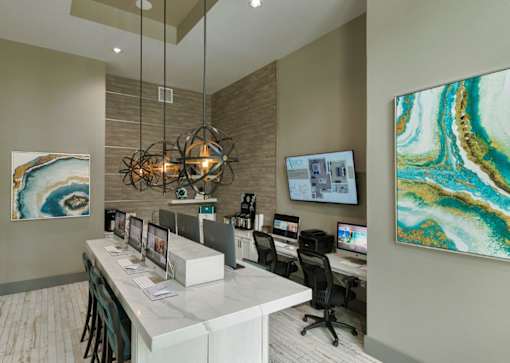 a reception area with computers and a large painting on the wall at The Addison on Long Bayou Apartments, Seminole, Florida