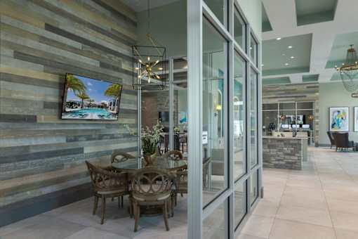 a dining room with glass doors and a table and chairs at The Addison on Long Bayou Apartments, Seminole, FL