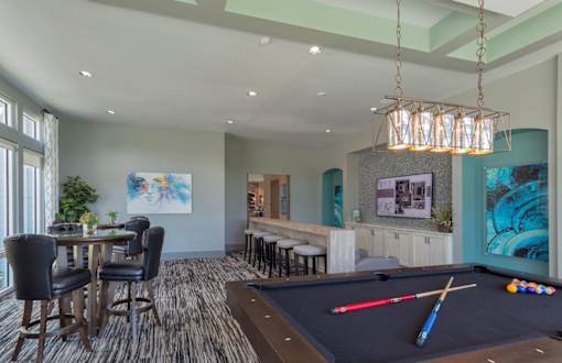 a game room with a pool table and a bar at The Addison on Long Bayou Apartments, Seminole, 33772