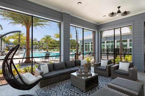 a living room with couches and a table and a swimming pool at The Addison on Long Bayou Apartments, Florida, 33772
