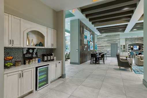 a kitchen with white cabinets and a table with chairs at The Addison on Long Bayou Apartments, Florida