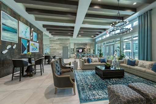a large living room with couches and chairs and a table at The Addison on Long Bayou Apartments, Seminole