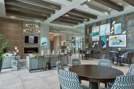a dining room with a table and chairs and a fireplace at The Addison on Long Bayou Apartments, Seminole, Florida