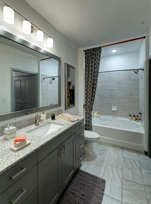 a bathroom with a sink and a shower and a toilet at The Addison on Long Bayou Apartments, Seminole