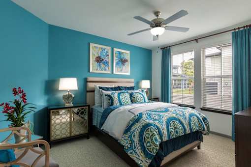 a bedroom with a bed and a ceiling fan at The Addison on Long Bayou Apartments, Seminole, FL, 33772