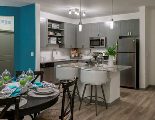 a kitchen with stainless steel appliances and an island with stools at The Addison on Long Bayou Apartments, Florida, 33772