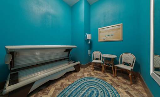 a seating area with two chairs and a piano in a blue room at The Addison on Long Bayou Apartments, Florida, 33772