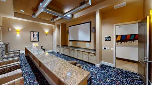 a large room with a long counter and a projector screen on the wall at The Millennium Towne Center Apartments, Baton Rouge, 70806