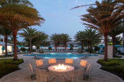 a large pool with a fire pit and chairs around it at Enclave at 3230 Apartments, Florida, 32119