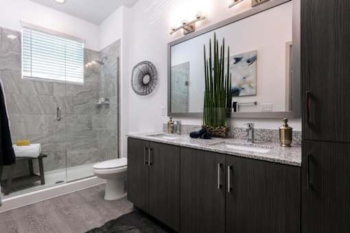 A bathroom with a toilet, sink, and mirror at Enclave at 3230 Apartments, South Daytona, 32119