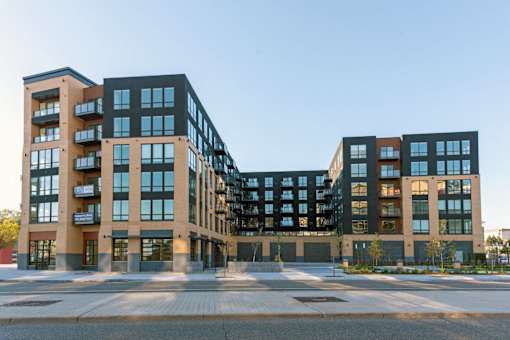 A modern multi-story building with a combination of beige and dark brown exterior. at The Arlow on Kellog, St. Paul, MN