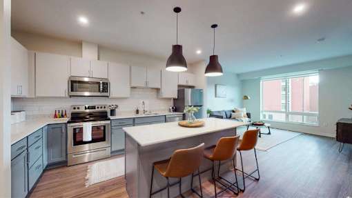 A modern kitchen with a large island and chairs. at The Arlow on Kellog, St. Paul, MN, 55102