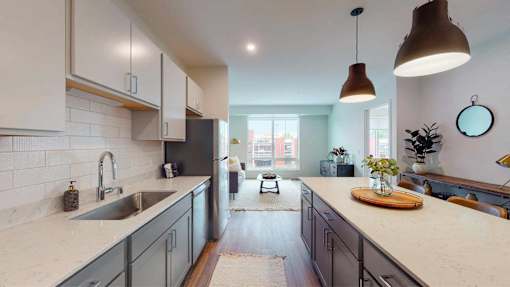 A kitchen with a white countertop and dark cabinets. at The Arlow on Kellog, St. Paul