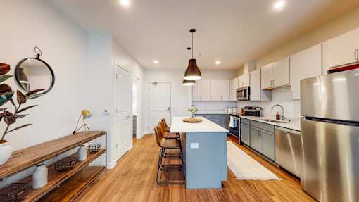 A modern kitchen with a blue island and stainless steel appliances. at The Arlow on Kellog, Minnesota