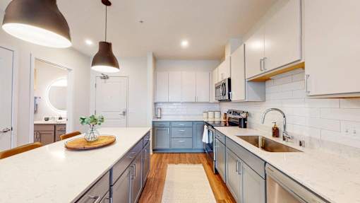 A kitchen with a white countertop and blue cabinets. at The Arlow on Kellog, Minnesota
