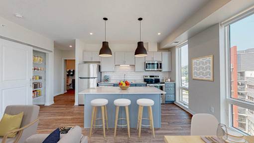 A modern kitchen with a bar stool and a dining table. at The Arlow on Kellog, Minnesota