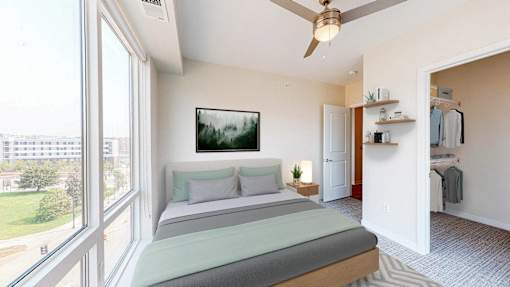 A bedroom with a large bed and a ceiling fan. at The Arlow on Kellog, Minnesota