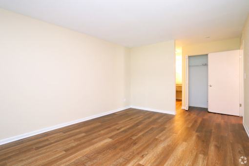 A room with wooden flooring and a white door.