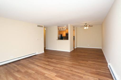 A room with wooden flooring and a ceiling fan.