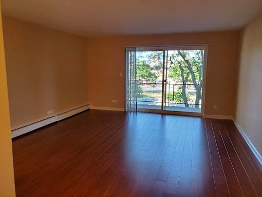 A room with wooden floors and a sliding glass door.