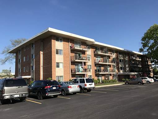 A parking lot with cars and a building in the background.