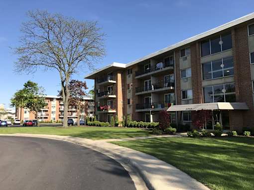 Apartment building with a tree in front of it.