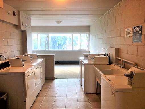 A clean, well-lit commercial kitchen with white appliances and tiled floors.