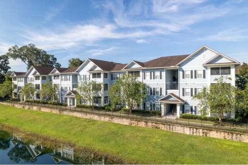 a large apartment complex with a grassy area in front of it at Magnolia Village Apartments, Jacksonville, FL, 32207