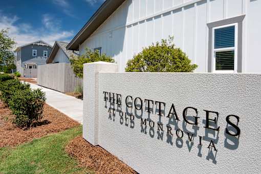 a white building with a sign at The Cottages at Old Monrovia Apartment , Huntsville, AL