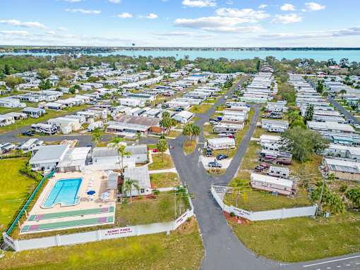 A bird's eye view of a residential area with a swimming pool and a road.
