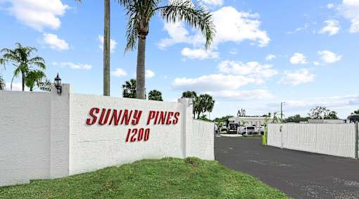 A white wall with the words "Sunny Pines 1200" painted on it.