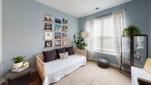 a bedroom with blue walls and a bed with a white comforter at The Bend Arbordale, Williamsburg, VA