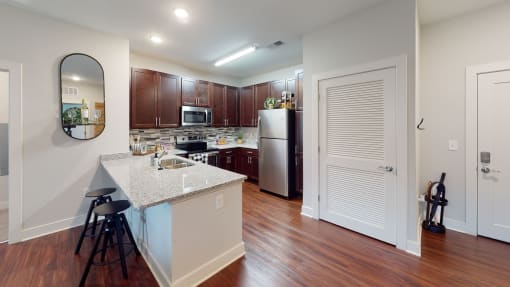 a kitchen with an island and stools at The Bend Arbordale, Virginia, 23188