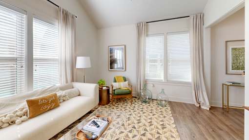 a living room with a white couch and a rug at The Cottages at Old Monrovia Apartment, Huntsville, AL, 35806