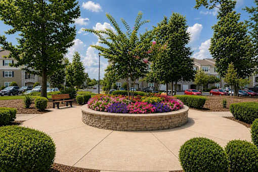 A circular garden with a bench in the middle of a courtyard.