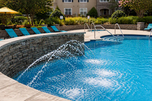A pool with a waterfall feature in the middle of it.