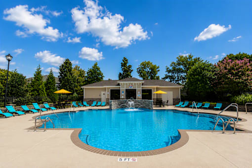 A large swimming pool with a waterfall feature in the middle.